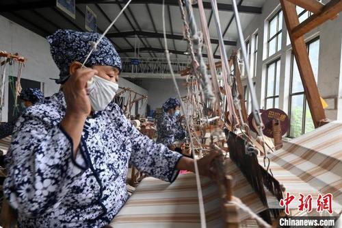 中国侨网图为工人正在织老粗布。翟羽佳摄