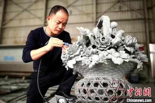 中国侨网中国工艺美术大师、惠安雕艺大师吴德强在创作中。　受访者供图