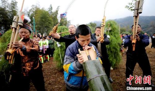 中国侨网一名苗族少年在古龙坡会上吹奏芦笙。　覃庆和 　摄