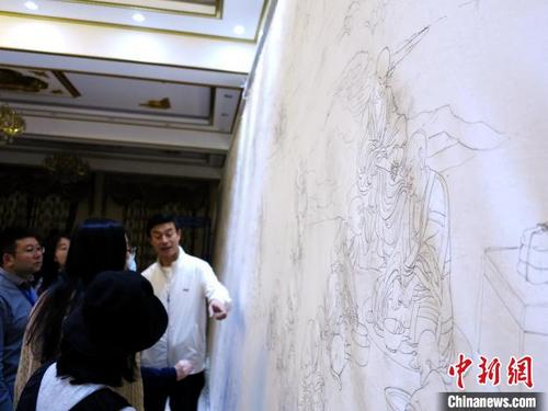 中国侨网图为“全国劳动模范”完德尖措介绍唐卡长卷的底稿。 张添福 摄