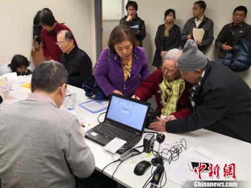 中国侨网工作人员为老年人办理证件。　中国驻纽约总领馆供图