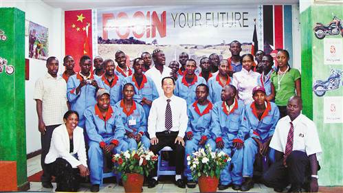 谢光綦和摩托车生产工厂部分工人合影。