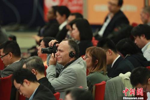 中国侨网10月17日，中国共产党第十九次全国代表大会新闻发言人庹震在北京人民大会堂举行新闻发布会。图为外国记者在发布会现场拍摄。 中新社记者 盛佳鹏 摄