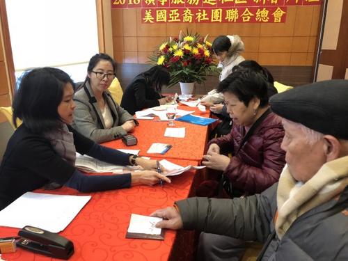 中国侨网董海荣(左二)正在帮助民众办证。(美国《世界日报》/黄伊奕 摄)
