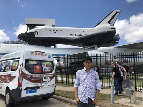 中国侨网图为樊玉虎与他上海牌照的汽车在休斯敦地标NASA太空中心留影。（美国《世界日报》/樊玉虎供图）