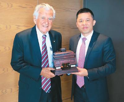 中国侨网图为陈玉树（右）向澳大利亚前总理霍克（左）赠送木雕作品《君子和平鼎》。