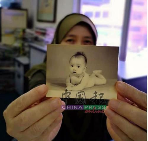 中国侨网哈丝玛手中这张逾半世纪的泛黄婴儿照，成了她寻回亲生家人的唯一线索。（马来西亚《中国报》）