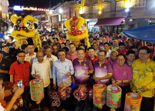 中国侨网甲州首长阿德里（左三）走入鸡场街与八大宗乡团庆中秋。（马来西亚《星洲日报》）