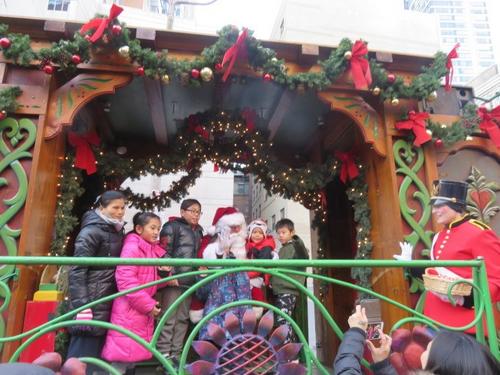 中国侨网美国波士顿华埠举行圣诞树点灯仪式，圣诞老人在列车和每个家庭合影。（美国《世界日报》／薛剑童 摄）