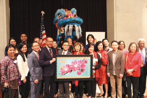 中国侨网众多官员和主办方人员，与今年的USPS猪年纪念邮票合影(左图)。（美国《世界日报》╱李晗 摄）