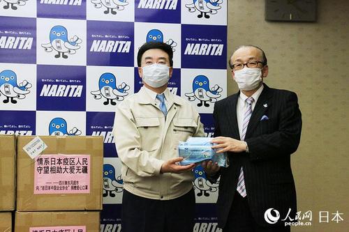 中国侨网在日中国企业协会会长王家驯（左）向成田市长小泉一成捐赠防护口罩。（人民网/李沐航 摄）