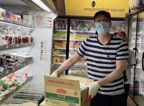 中国侨网吴建锡在超市搬货(美国《世界日报》/牟兰 摄)