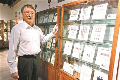 中国侨网黄添向记者介绍他所捐赠的珍贵邮票。