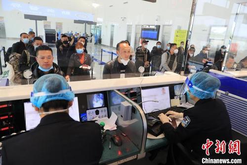 中国侨网图为边检人员为乘客办理乘机手续。　塔娜　摄