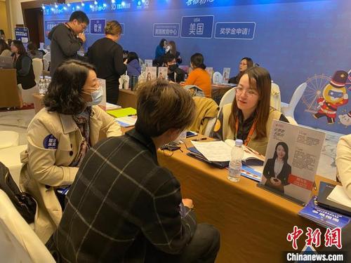 中国侨网17日在启德国际教育展上，学生和家长正与留学顾问交流。　杨在扬　摄