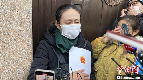 中国侨网江秋莲拿到判决书后接受媒体采访。　刘延珉　摄
