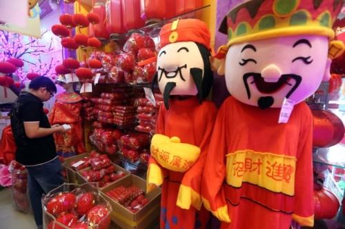中国侨网售卖新年装饰的业者在店里放置可爱的财神爷，以吸引顾客。(马来西亚《星洲日报》)