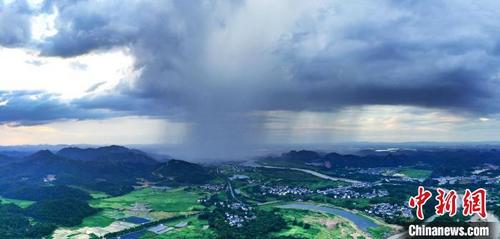 中国侨网7月26日傍晚，一道“雨瀑”在龙虎山从北往西移动，云层和大地连为一体，犹如大地和云层挂起了纱帐。 舒鹏 摄