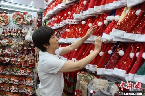 中国侨网义乌商户整理档口展示的众多圣诞帽样品。董易鑫摄