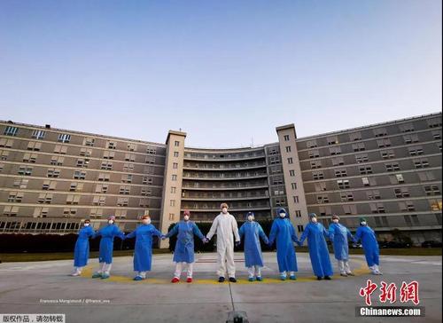 中国侨网资料图：意大利克雷莫纳一家医院的医务人员手牵手，向在新冠肺炎疫情中受影响的人们表示支持和致意。
