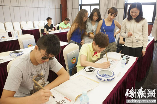 7月29日，美国华裔少年刘一多（左一）与同伴练习书法时获“粉丝”们围观。（美国《侨报》/李洪