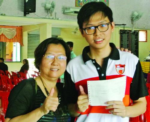 中国侨网胡嘉骏（右）与母亲黄秀花分享考获全A的喜悦。（马来西亚《光华日报》）