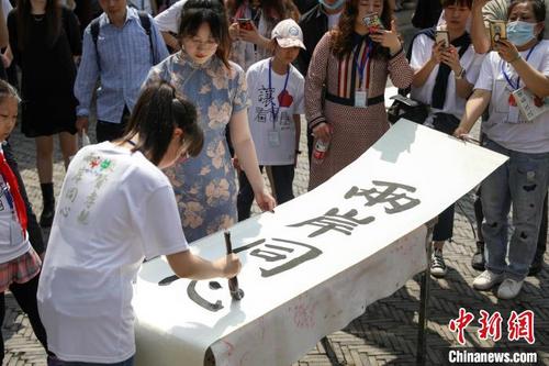 中国侨网两岸学生代表共同书写“敬贤孝亲、两岸同心”。　张亨伟　摄