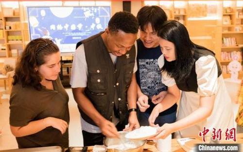 中国侨网图为外国留学生探索月饼制作中和面的窍门。黄维正摄