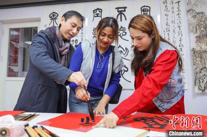 中国侨网外国友人向老师学习毛笔书法。张鹰 摄