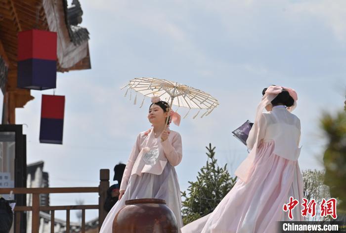 中国侨网在吉林省延边州延吉市的中国朝鲜族民俗园内，游客身着朝鲜族服饰拍照。张瑶 摄