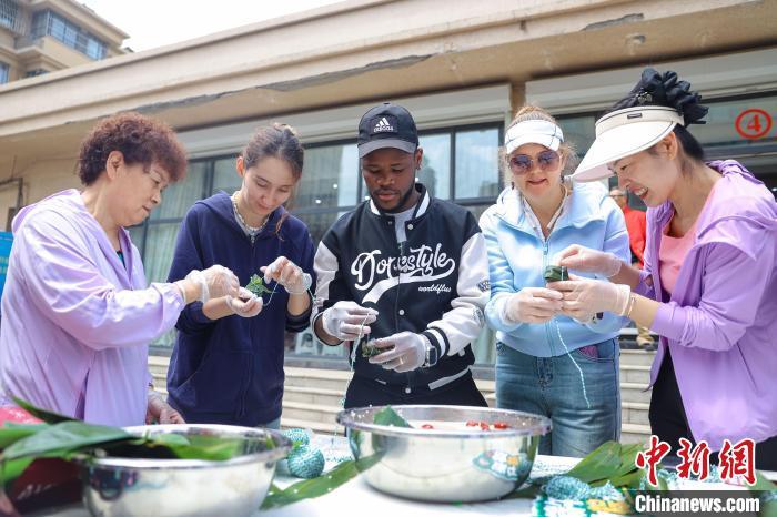 中国侨网6月5日,外籍友人学习包粽子。当日,来自俄罗斯、塔吉克斯坦、加拿大的外籍友人,在山东省青岛市沉浸式体验传统裹粽、艾草花束和艾草锤制作等端午民俗,实地感受中国传统文化的魅力和深厚的历史底蕴。 张鹰 摄