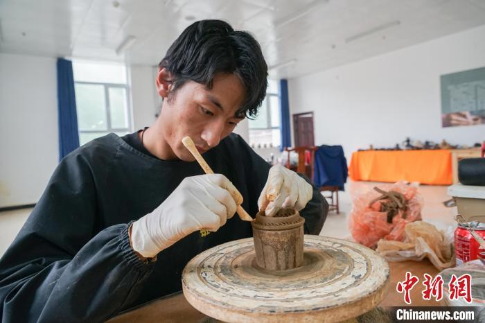 中国侨网7月18日,在班玛黑陶培训及体验中心,学员正在制作班玛黑陶作品。黑陶工艺在青海省果洛藏族自治州班玛县已传承了600多年,至今仍保留原始的手工制作方法,经过取土、和泥、打磨、捏制、发酵、火烧、熏黑、抛光等12道工序制成,是青海省非物质文化遗产。班玛黑陶种类繁多,多为壶、灯盏、坛、罐等藏族民众日常用品、工艺品。如今,黑陶已成为班玛县特色旅游产品,不断创新的黑陶产品畅销国内市场,黑陶产品制作也成为当地民众增收新渠道。中新社记者 马铭言 摄