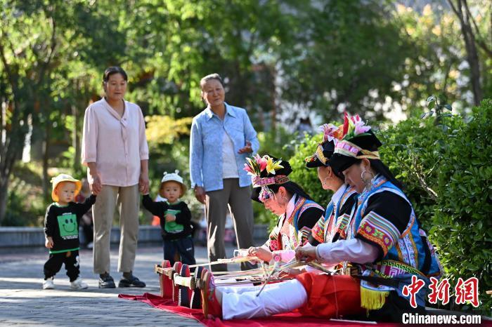 中国侨网9月26日，甘肃省甘南藏族自治州舟曲县，当地藏族妇女纺织锦带吸引游人驻足观赏。锦带是舟曲藏族妇女用以束腰、扎靴、拢发乃至点缀服饰的花带子，艳丽多彩、图案优美。每逢吉庆节日，藏族妇女穿戴的华丽盛装就需要少则五、六条，多则十几条宽窄长短相宜的锦带来装饰。据介绍，藏族织锦带技艺历史悠久，一千多年以前，古羌族和吐蕃已有了较发达的手工编织技术，在艰难的生活条件下对服饰等生活用品除实用功能之外，已经有了强烈的审美追求，是研究舟曲羌藏文化的“活化石”。中新社记者 九美旦增 摄