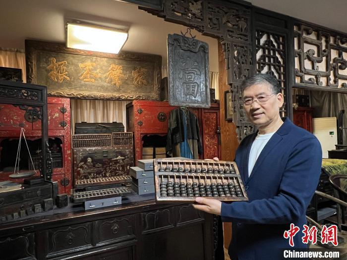 中国侨网晋商学者、山西财经大学晋商研究院客座教授陈旭向记者介绍自己收藏的算盘。中新社记者 杨杰英 摄