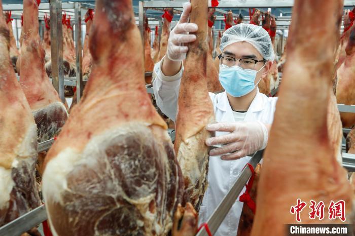 中国侨网12月30日,工作人员正在晾晒徽州腊味。岁末将至,正是传统腊味加工的好季节,在安徽省黄山市黄山区一家企业的晒场上,工作人员将火腿、腊肉、腊肠进行晾晒,供应市场,徽州传统腊味飘香全国,年味浓浓。施亚磊 摄