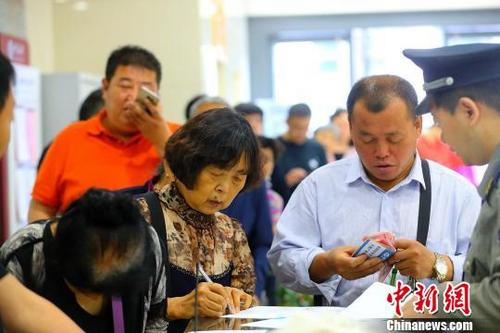 中国侨网民众在银行排队兑换纪念币。 张云 摄