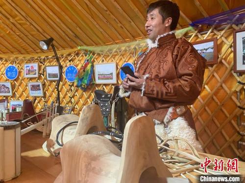 中国侨网图为布和正在向游客介绍自己正在制作的马鞍子。　奥蓝　摄