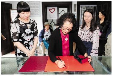 徐行在留言簿上留言。 ■记者 王超英 摄