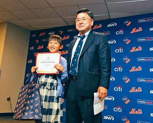 林子彤（左）获得一枚奖章和用于买更多书的礼品卡。（图片来源：美国《星岛日报》）