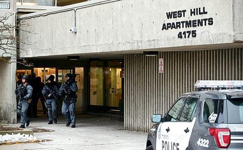 多伦多士嘉堡发生枪杀案，大批特警手持长枪进入案发柏文大厦调查。（加拿大《星岛日报》）