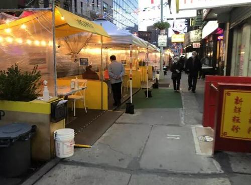 纽约市府规定参与开放餐厅计划业者，须在12月中前以沙包、反光条等设备保护户外用餐空间。(美国《世界日报》/颜嘉莹 摄)