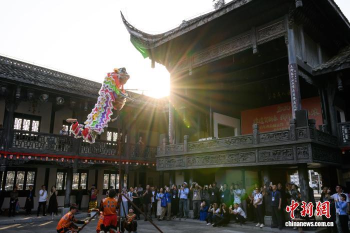 4月19日,2026海外华媒侨领走进渝东南联合参访活动走进重庆市秀山土家族苗族自治县,30余家主流华文媒体和10余位知名侨领在秀山西街观看高台狮舞表演,沉浸式感受巴渝民俗文化魅力。图为海外华媒侨领观看高台狮舞表演。中新社记者 何蓬磊 摄