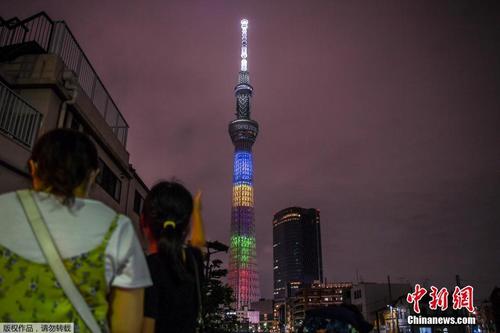 日本多处建筑亮五环色 纪念东京奥运会倒计时一周年