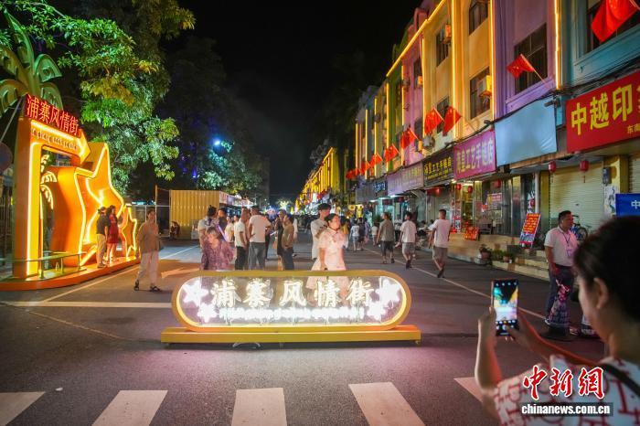 8月27日晚,广西凭祥市,近期开街的浦寨风情街吸引不少市民游客前来“夜逛”。该风情街临近浦寨口岸,以“梦幻浦寨·跨国不夜城”为主题,以中越边关风情为主线,融入东盟特色、边关文化等设计元素而打造。中新社记者 陈冠言 摄