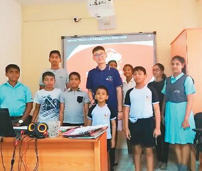 许安（中）和学生们在一起。（图片来源：《人民日报海外版》）