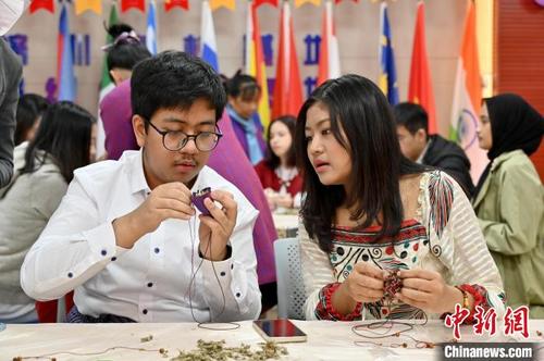 图为留学生体验制作壮锦葫芦香包。　俞靖　摄