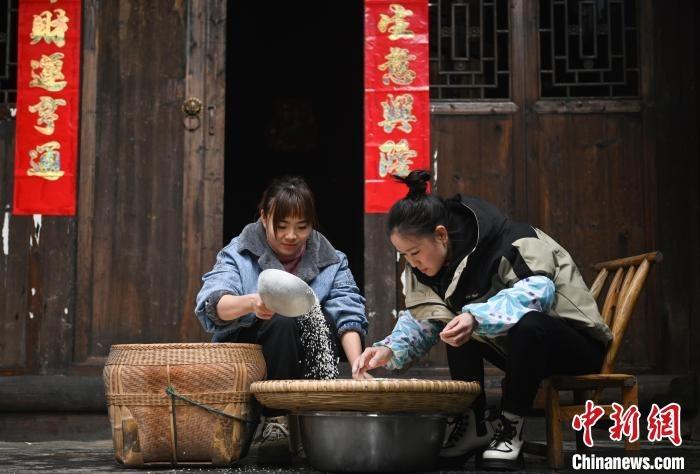 图为村民在挑选大米准备制作米豆腐。谢慧芳 摄