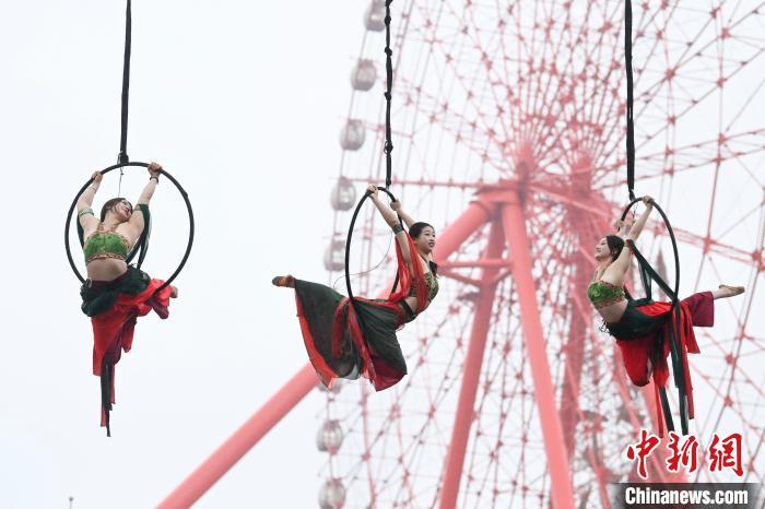 杂技表演者在摩天轮下翩翩起舞。新时社网记者 杨华峰 摄