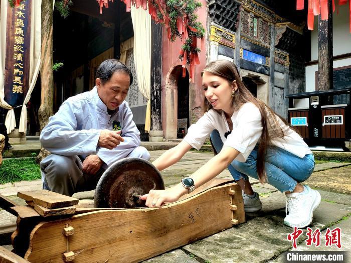 图为游客正在三皇宫体验中药炮制技术。吴思瑜摄