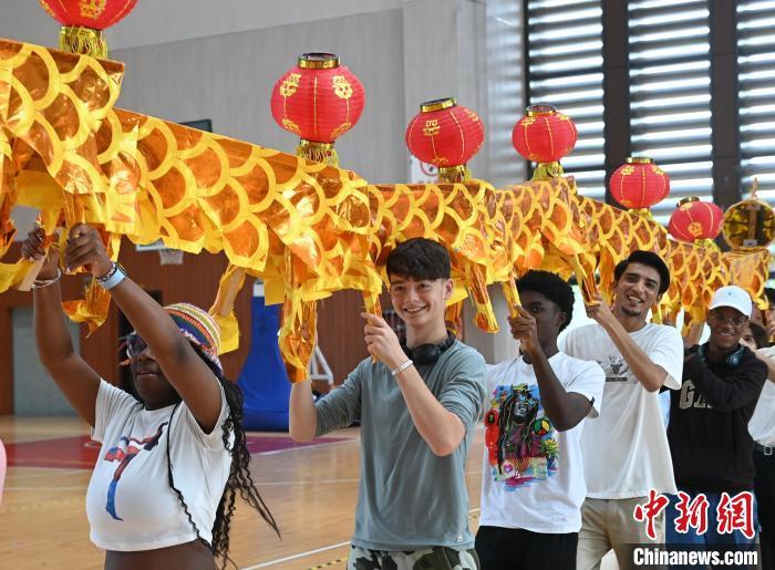 8月1日,在黄山学院,美国青年和该校学生一起体验舞动板凳龙。7月30日至8月1日,来自美国马里兰州的高中生研学团一行在安徽黄山开启徽州之旅,在文化交流间尽显情谊。中新社记者 韩苏原 摄
